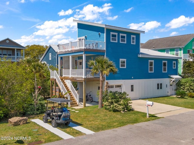 view of front of house featuring a porch, a front yard, and a garage