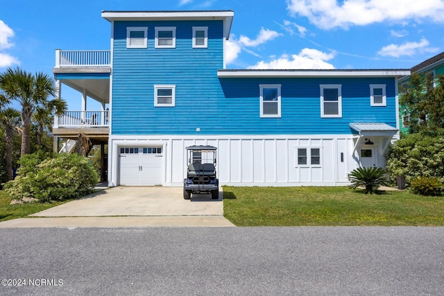 front facade with a balcony, a front lawn, and a garage