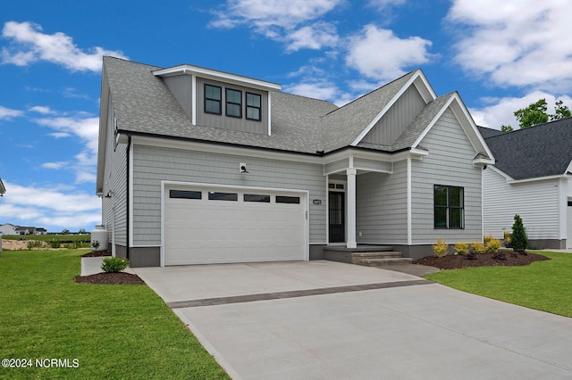 view of front of home with a front yard and a garage