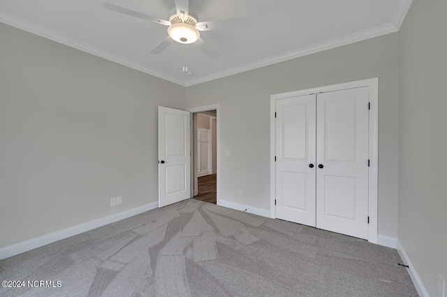 unfurnished bedroom featuring ceiling fan, ornamental molding, light carpet, and a closet