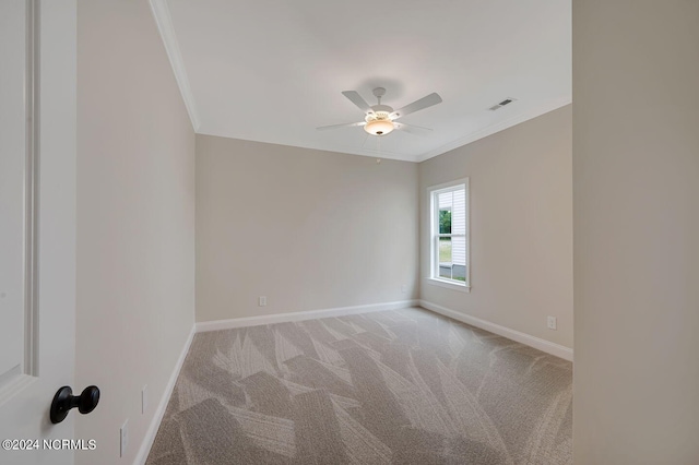 empty room featuring light carpet, crown molding, and ceiling fan