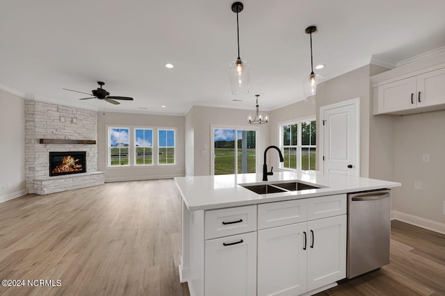 kitchen featuring sink, stainless steel dishwasher, an island with sink, white cabinets, and ceiling fan with notable chandelier