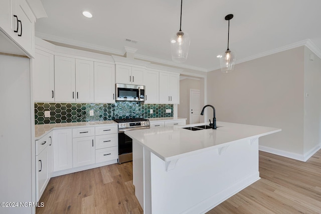 kitchen featuring white cabinets, a center island with sink, hanging light fixtures, sink, and appliances with stainless steel finishes