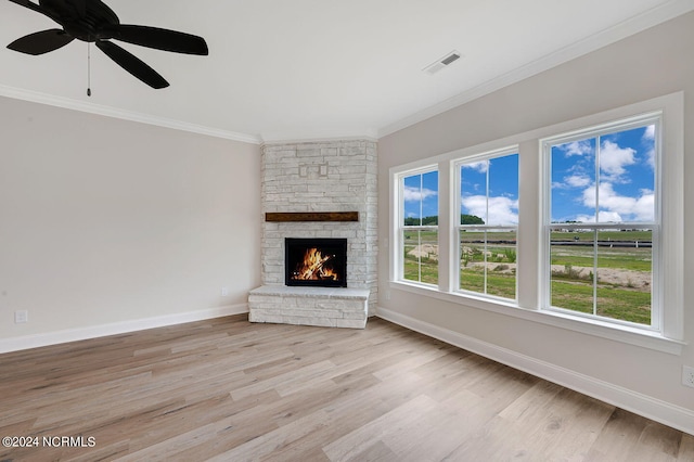 unfurnished living room with a fireplace, light hardwood / wood-style flooring, ceiling fan, and crown molding