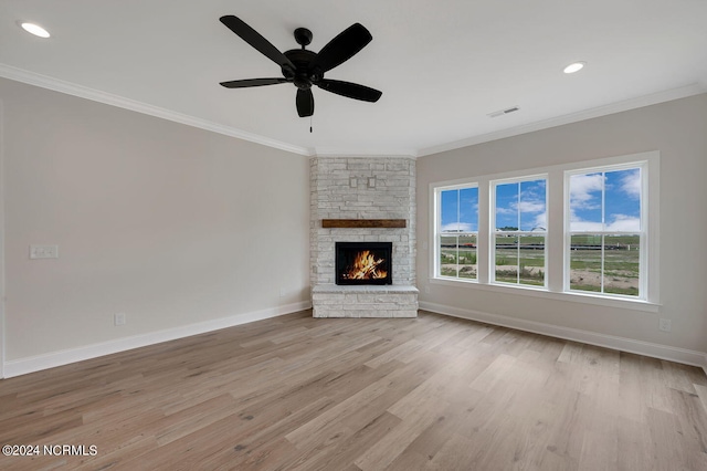 unfurnished living room featuring crown molding, a fireplace, ceiling fan, and light hardwood / wood-style flooring