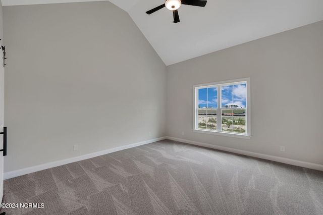 empty room featuring light carpet, ceiling fan, and vaulted ceiling