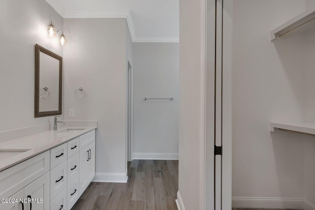 bathroom featuring vanity, hardwood / wood-style flooring, and ornamental molding