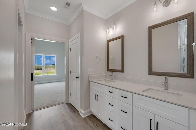 bathroom with hardwood / wood-style floors, vanity, and ornamental molding