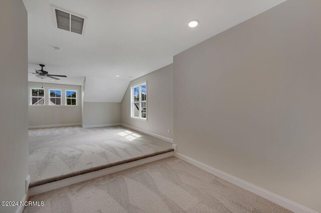 spare room featuring light carpet, ceiling fan, and lofted ceiling