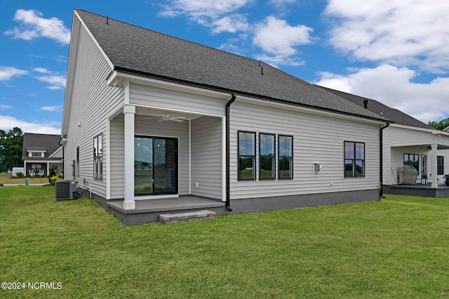 rear view of house with a lawn, ceiling fan, and central AC unit