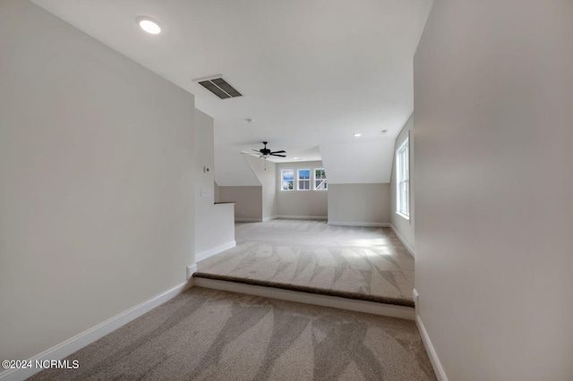 interior space with ceiling fan and light colored carpet