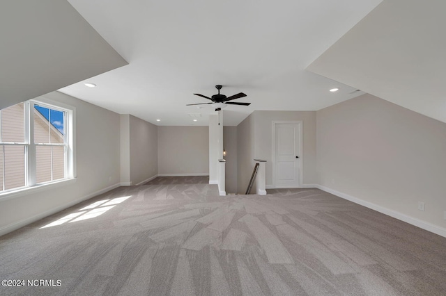 additional living space featuring light carpet and ceiling fan