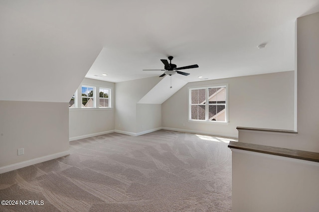 additional living space featuring ceiling fan, lofted ceiling, and light carpet