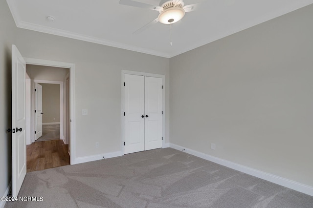 unfurnished bedroom with carpet, a closet, ornamental molding, and ceiling fan