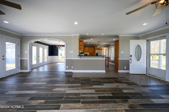 entrance foyer featuring crown molding, french doors, and ceiling fan with notable chandelier