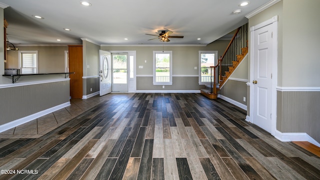 unfurnished living room with dark hardwood / wood-style floors, ornamental molding, and ceiling fan