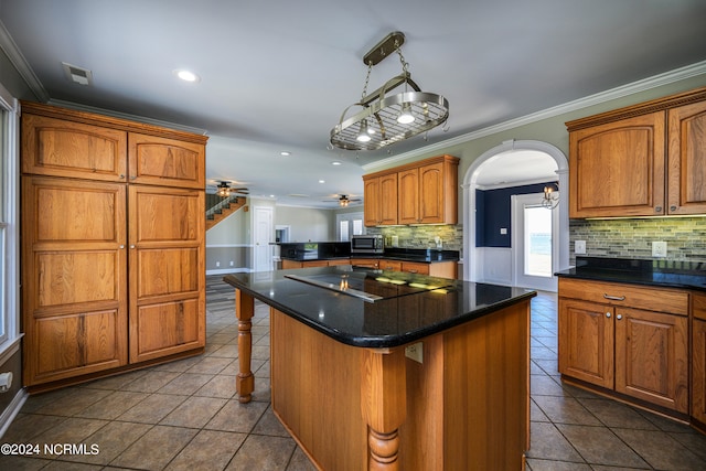 kitchen with a breakfast bar, a kitchen island, tasteful backsplash, and ceiling fan