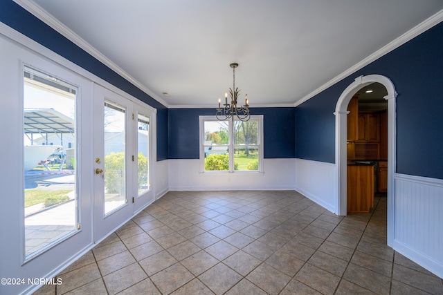 unfurnished room featuring dark tile flooring, a wealth of natural light, a chandelier, and crown molding