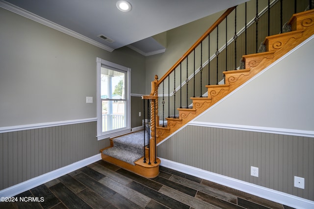 stairs with dark hardwood / wood-style flooring and crown molding