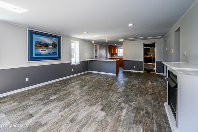 unfurnished living room featuring ornamental molding and dark hardwood / wood-style floors