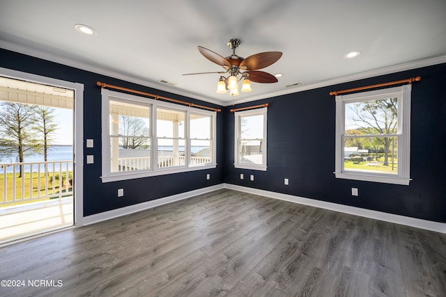 spare room with plenty of natural light, ornamental molding, ceiling fan, and dark hardwood / wood-style flooring