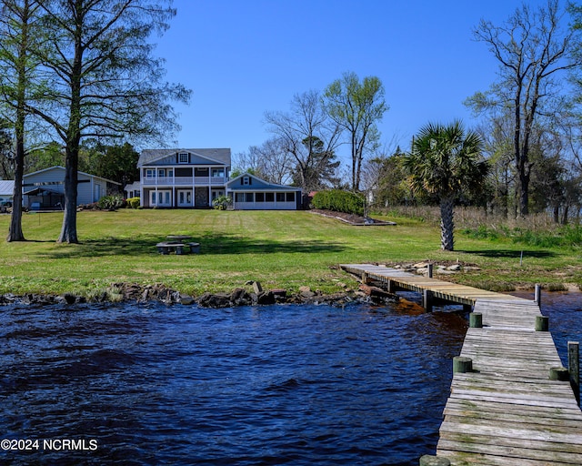 dock area with a water view and a lawn