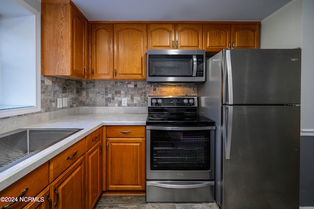 kitchen featuring backsplash, stainless steel appliances, and dark tile flooring