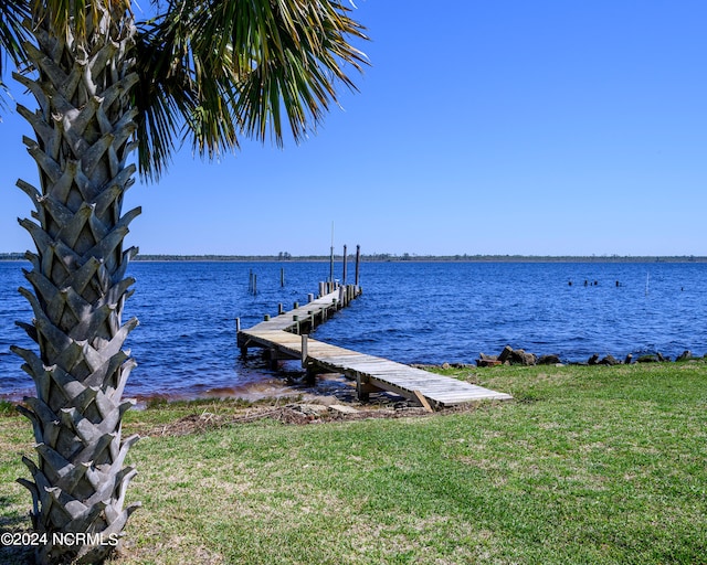 view of dock featuring a water view and a yard