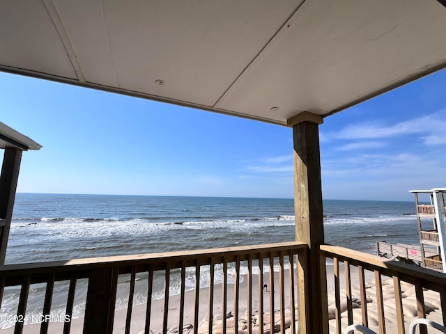 balcony featuring a water view and a view of the beach