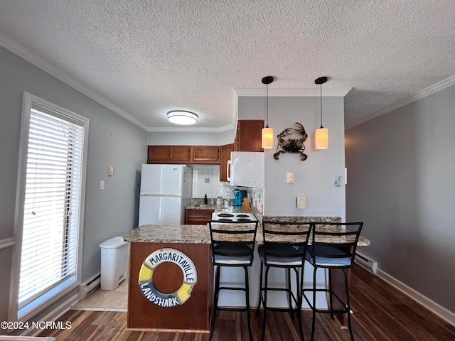 kitchen with a healthy amount of sunlight, pendant lighting, dark hardwood / wood-style flooring, and white refrigerator