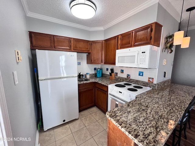 kitchen with backsplash, decorative light fixtures, white appliances, and a textured ceiling