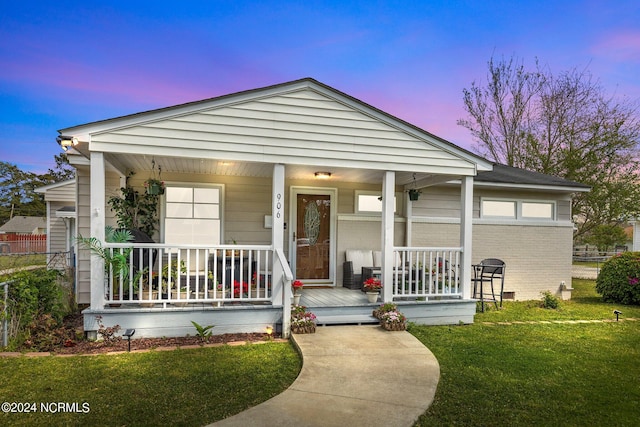 view of front of home featuring a porch and a lawn