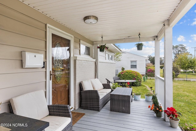 wooden terrace with outdoor lounge area and a yard