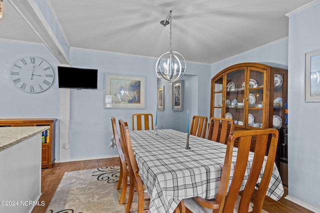 dining area with a chandelier, ornamental molding, and dark hardwood / wood-style floors