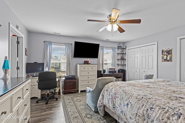 bedroom with ceiling fan, dark wood-type flooring, and a closet