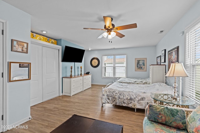 bedroom featuring light hardwood / wood-style flooring, ceiling fan, and a closet