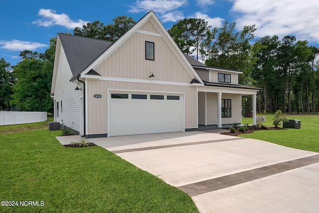 view of front facade featuring covered porch, central AC, a garage, and a front yard