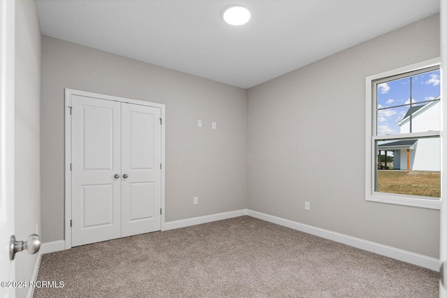 unfurnished bedroom featuring carpet floors and a closet