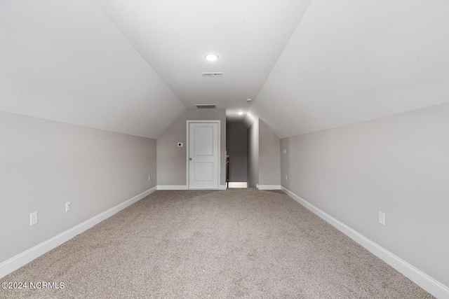 bonus room with lofted ceiling and carpet