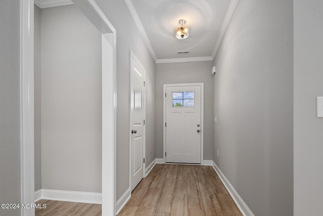 doorway to outside with ornamental molding and light hardwood / wood-style floors