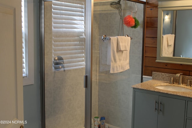 bathroom with a shower with shower door and vanity