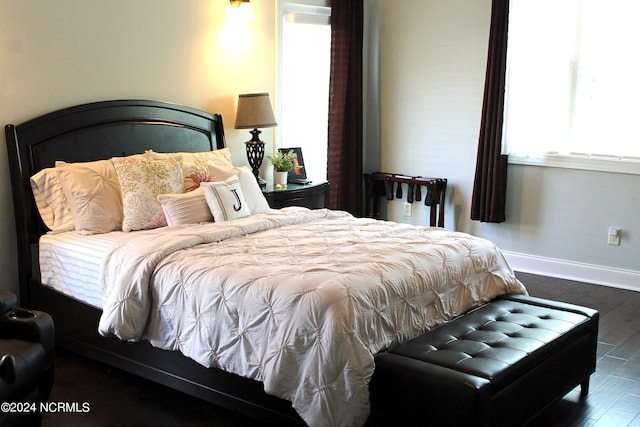 bedroom with dark hardwood / wood-style floors