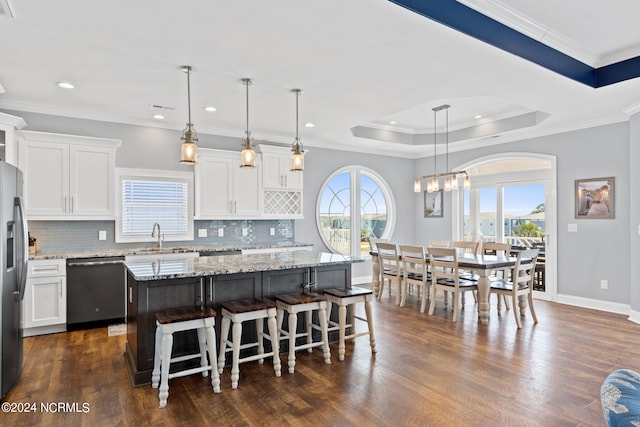 kitchen featuring appliances with stainless steel finishes, a kitchen island, hanging light fixtures, dark hardwood / wood-style floors, and tasteful backsplash