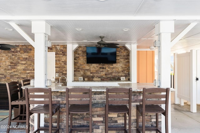 view of patio featuring an outdoor bar and ceiling fan