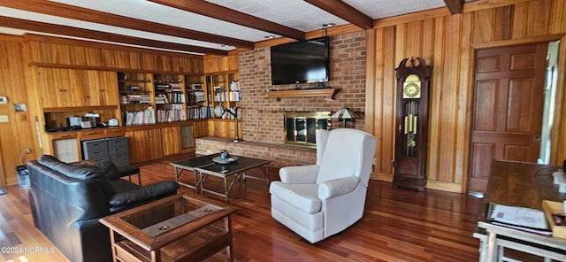 living room featuring beamed ceiling, wood walls, a brick fireplace, and dark wood-type flooring