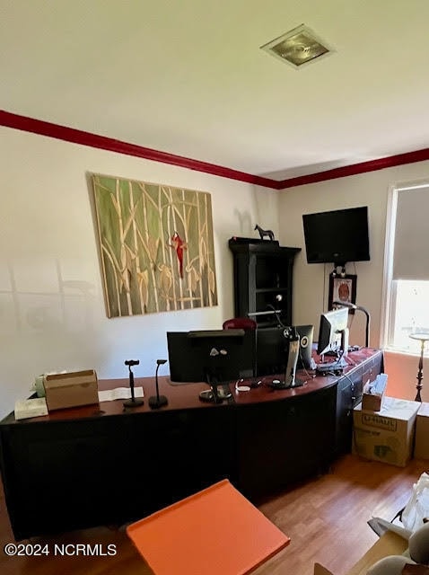 office area with hardwood / wood-style floors and crown molding