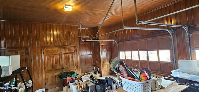 garage featuring wood ceiling and wood walls