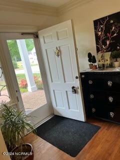 entryway with ornamental molding and dark hardwood / wood-style flooring