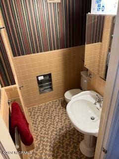 bathroom with tile walls, toilet, and tile flooring