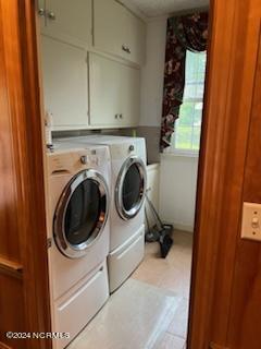 washroom featuring cabinets, separate washer and dryer, and light tile floors